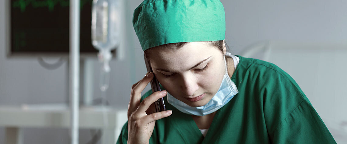 Doctor in scrubs using phone